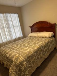 亚特兰大Cozy - Home Away From Home with Free Parking的一间卧室配有一张床、床罩和窗户