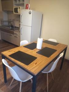 佩里托莫雷诺Laguna de los Cisnes的厨房配有木桌、椅子和冰箱