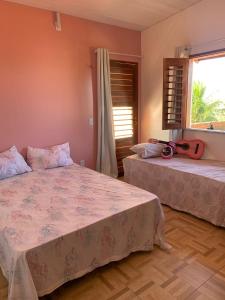 帕拉库鲁Happy Hostel e Pousada Paracuru的一间卧室设有两张床和窗户。