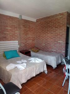 米娜克拉韦罗Complejo Navi的一间设有两张床和砖墙的房间