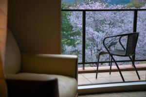 京都Riverte Kyoto Kamogawa的坐在窗前的椅子