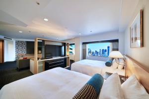 东京东京新大谷酒店花园塔酒店的酒店客房设有两张床和一台平面电视。