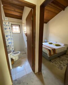 伊利亚贝拉Suítes Canto do Nema的一间卧室配有一张床,浴室设有卫生间