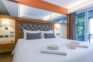 华欣Golden Sea Hua Hin - SHA Extra Plus的一间卧室配有一张大床,上面有两条白色毛巾