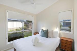 Lake CathieReflections Bonny Hills - Holiday Park的卧室配有白色的床和2个大窗户