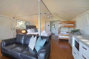 Lake CathieReflections Bonny Hills - Holiday Park的带沙发的客厅和帐篷内的1张床