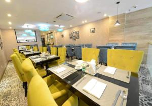 河内Hanoi Emerald Waters Hotel Valley的餐厅设有黄色椅子和长桌