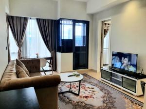 吉隆坡Star Residence KLCC By FZB的带沙发和电视的客厅
