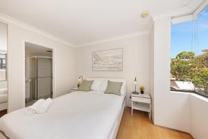 悉尼Spacious & Cosy 2 Bedroom Apartment in Darling Harbour的白色的卧室设有一张大床和一个窗户
