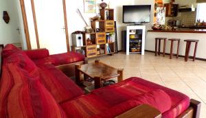 TevaitoaLa Maison Du Voyage的客厅配有红色的沙发和桌子