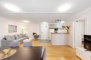 悉尼Spacious & Cosy 2 Bedroom Apartment in Darling Harbour的客厅配有沙发和桌子