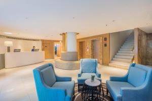 曼谷Citrus Sukhumvit 11 by Compass Hospitality的大堂设有蓝色椅子和楼梯