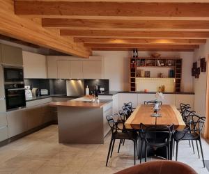 雷加霍斯达哈施Chalet Arpitan - les Carroz - Grand Massif的一个带木桌和椅子的大厨房