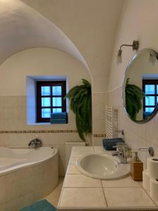 米库洛夫VIP MiKU apartman 2的带浴缸、水槽和镜子的浴室