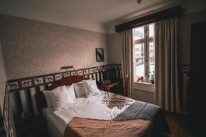 厄勒布鲁Mojo Hotell的一间卧室配有一张带白色床单的床和一扇窗户。