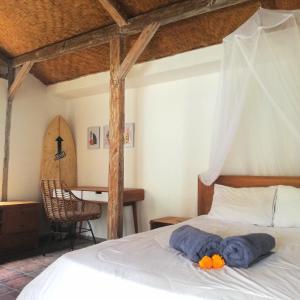 海神庙The Joglo Kedungu, Traditional Teakwood的一间卧室配有一张带蓝色毛巾的床