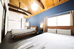 东京ACT one的一间卧室设有两张床和蓝色的墙壁