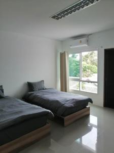 拉威海滩Baan7984 Rawai的卧室设有两张床,带窗户