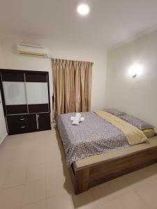 迪沙鲁Balini Home Tiara Desaru的一间卧室配有一张床,上面有两条毛巾