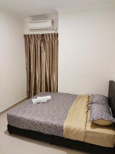 迪沙鲁Balini Home Tiara Desaru的一间卧室配有一张床,上面有两条毛巾