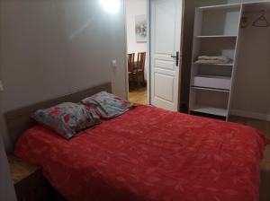 欧波讷Appartement Eaux bonnes的一间卧室配有一张红色棉被的床