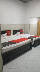 HaguVina Vira Hotel的带3张红色床单的房间