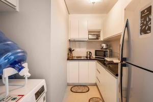长滩岛QUIET HOME with private beach的小厨房配有白色橱柜和冰箱。