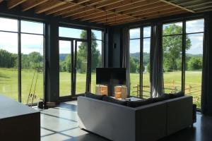 厄尔科Modern Villa & Sauna by the lake, przytulnavilla, Dom nad jeziorem na Mazurach的带沙发、电视和窗户的客厅