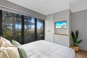 尤朗加Reflections Urunga - Holiday Park的一间卧室设有一张床和一个大窗户