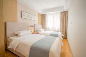苏州红璞礼遇酒店的酒店客房设有两张床和窗户。