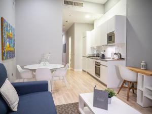 马德里Arenal Suites Gran Vía的客厅以及带桌椅的厨房。