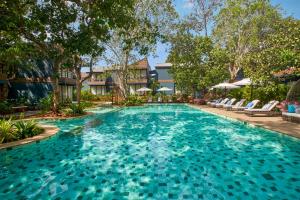 安君纳Avataara Resort & Spa的一座带椅子和树木的度假村游泳池