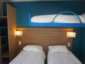 滨海贝尔克The Originals Access, Hôtel les Iris, Berck-sur-Mer的带两张双层床的客房中的两张床