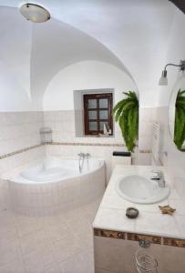 米库洛夫VIP MiKU apartman 2的白色的浴室设有浴缸和水槽。