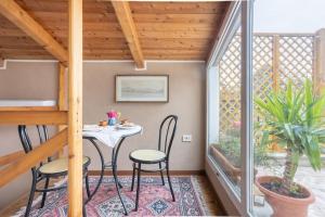 博洛尼亚Lo chalet di Giulia - Romantic terrace的阳台的小型用餐室配有桌椅