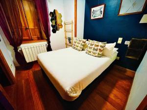 纳瓦塞拉达El Torreon de Navacerrada的卧室配有白色床和蓝色墙壁