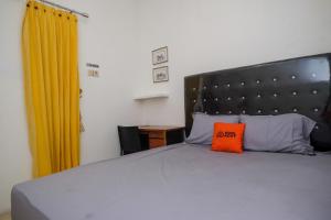 SukoharjoKoolKost Syariah near Luwes Gentan Park (Minimum Stay 30 Nights)的床上有一个橙色枕头