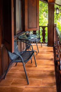 琅勃拉邦Villa Mira Heritage的门廊配有2把椅子和桌子