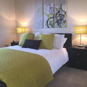 阿伯丁AB11公寓 - 波特兰街的卧室配有一张带绿床单和枕头的大床。