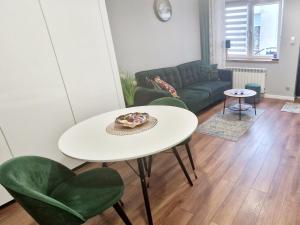 厄尔科Promenada Room Ełk的客厅配有白色桌子和绿色椅子