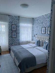 马斯特兰德航海酒店的一间卧室配有一张蓝色和白色壁纸的大床