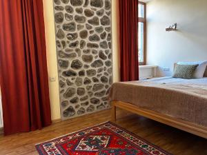 戈里斯Saryan Guesthouse的一间卧室设有石墙和一张床
