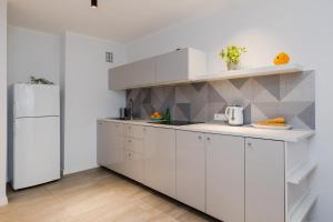 华沙ShortStayPoland Grzybowska (B73)的厨房配有白色橱柜和白色冰箱。