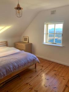 巴利康尼利Pink Cottage的一间卧室设有一张床和一个窗口