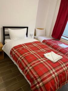 伦敦27 Argyle Square的宿舍间内的两张床和红色的铺地毯子