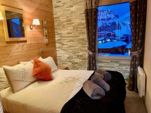阿沃里亚兹Luxury Chalet with sauna by Avoriaz Chalets的卧室配有带枕头的床铺和窗户。