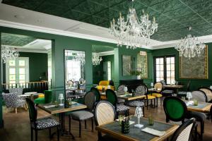 开普敦凯普卡多根精品酒店的餐厅拥有绿色的墙壁和桌椅