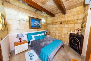 瓦莱塔Valletta Traditional Townhouse的带壁炉的客房内的一间卧室配有一张床