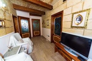 瓦莱塔Valletta Traditional Townhouse的客厅配有平面电视和沙发。