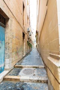 瓦莱塔Valletta Traditional Townhouse的两座建筑之间在旧城的空洞小巷